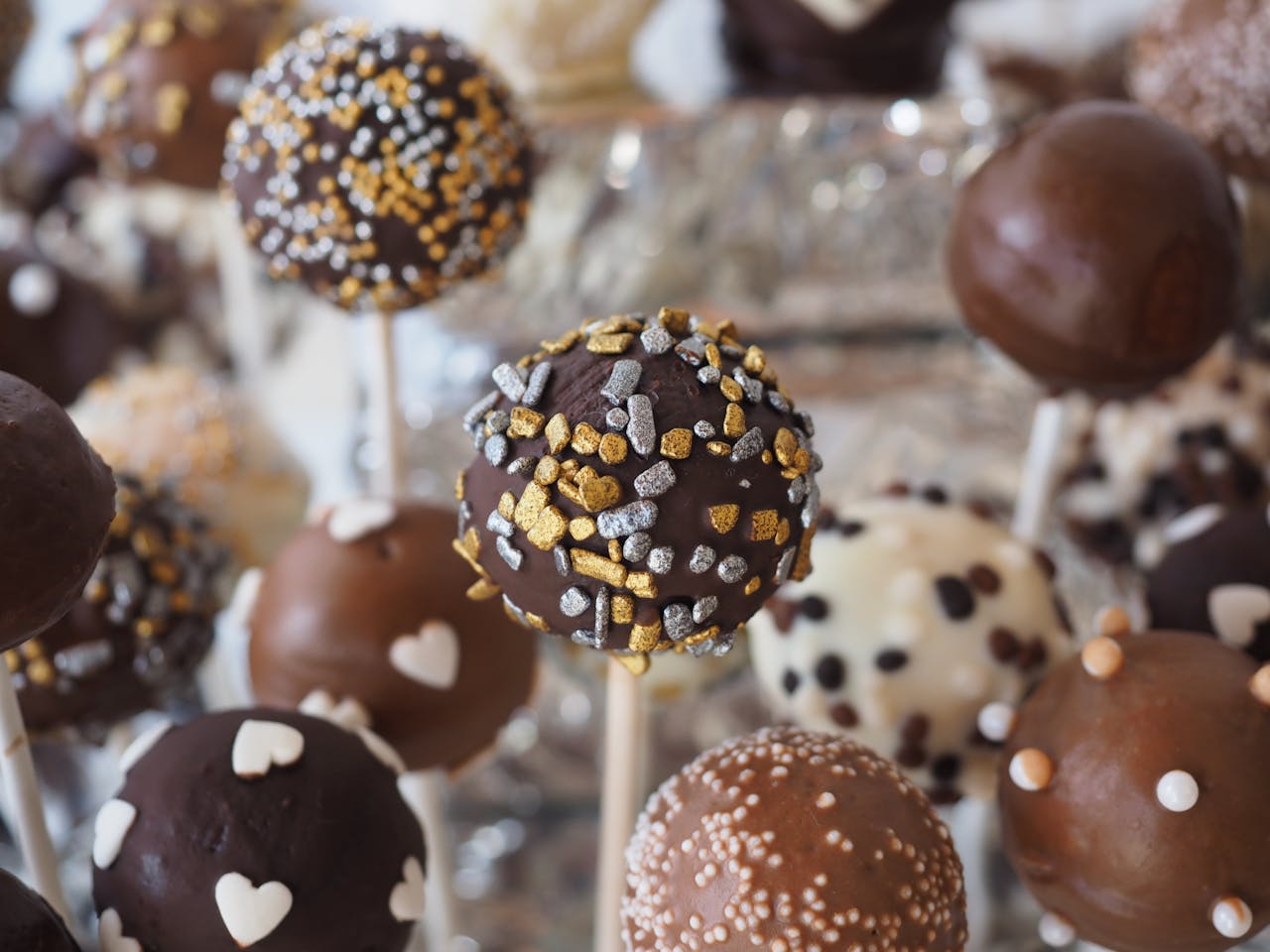 Close-up of assorted cake pops with chocolate and decorative toppings perfect for dessert tables.